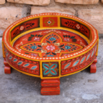 A wooden round chakki table showcasing a fusion of craftsmanship and functionality.